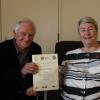 Julia Morton-Marr presents a Peace Garden Certificate to Roy Clements in recognition of the REAF (Refugee Education for Adults and Families) programme at Selwyn College.